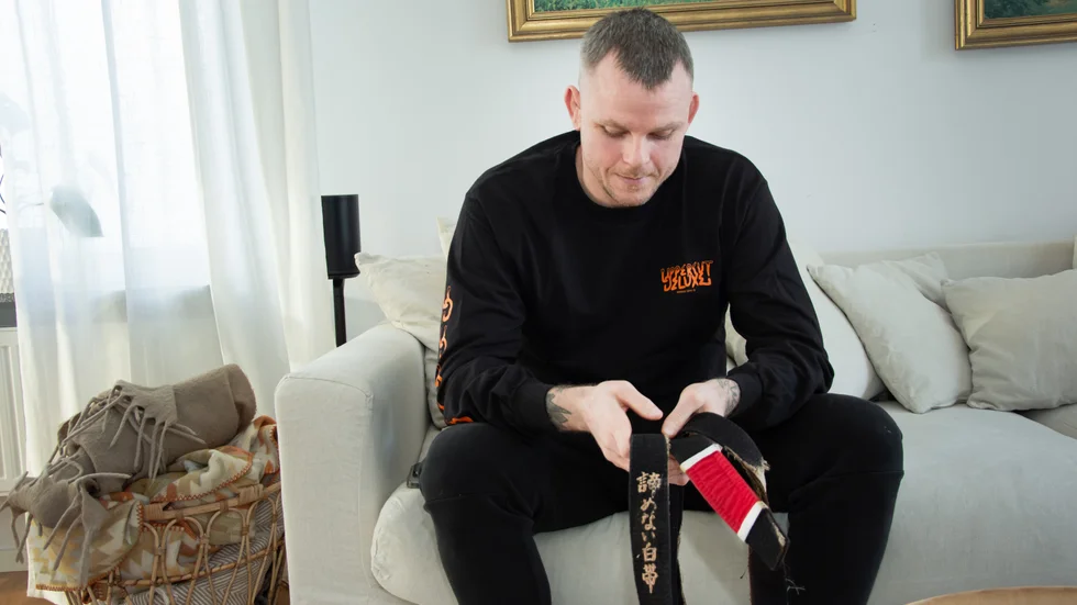 Niklas Bäckström håller i det svarta bälte som klarade branden. "Jag ska rama in det", säger han.