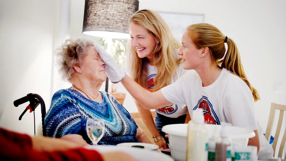 Yvonne Ryding bistår med goda råd när Birgit Englund, får en ansiktsbehandling av Eskilstuna Uniteds Vaila Barsley. "Detta var helt underbart", utbrister 91-åringen.