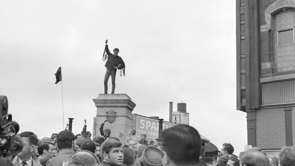 Demonstrant i Chicago 1969 står på piedestalen till den staty över en polisman från Haymarketmassakern som sprängts några dagar tidigare. 