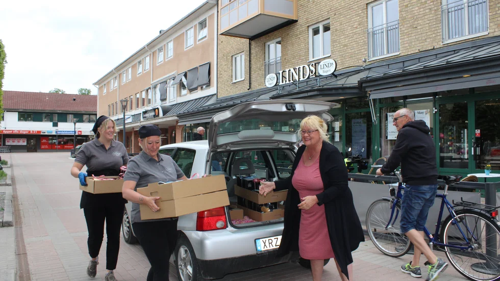 Här kommer Wilma Ekström och Sandra Lindander på Linds med kartonger fyllda med nationaldagsbakelser som Ann Svensson ska leverera till alla på särskilt boende i Åtvidaberg.