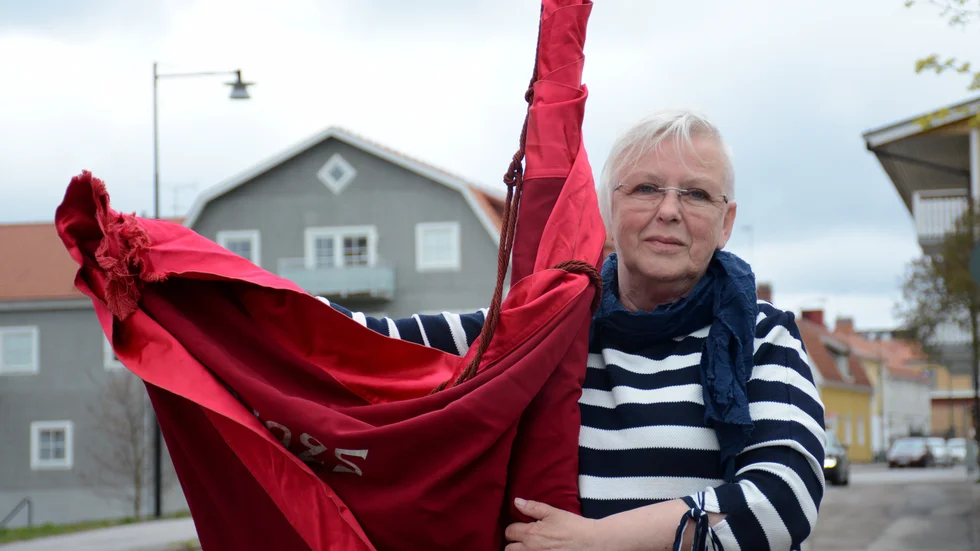 Eva Berglund med arbetarkommunens fana från 1925. I år får den stå kvar i förrådet på partiexpeditionen. "Jag tror det har hänt en gång förut när det var snöoväder den första maj", säger hon inför årets intsällda demonstrationståg.