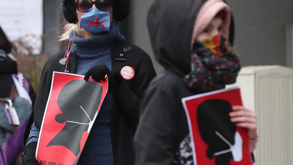 Kvinnorättsaktivister i munskydd demonstrerar mot den polska regeringens åtgärder i Warszawa. Arkivbild.