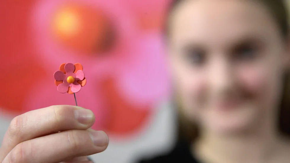 Årets majblomma är rosa och orange med en gul prick i mitten. På grund av coronapandemin är försäljningen uppskjuten till i höst även i Enköping.