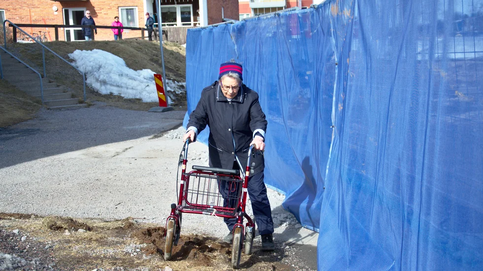 Seija Vilmunen får kämpa med alla sina krafter för att ta sig upp över den lilla slänten och forcera sig fram över grushögarna för att ta sig ut på gatan till huset.