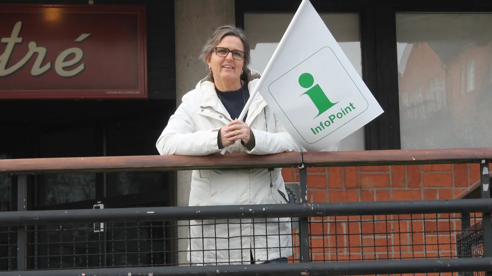 Pia Axelsson, ansvarig för Besöksservice och Infopoints på Tillväxt Motala AB, flaggar för det kommande sommarkontoret med turistinformation i Motala Folkets Hus foajé.