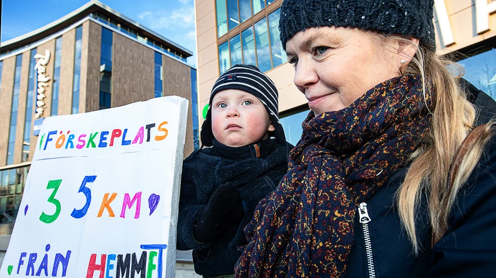 Miia Riihimäki demonstrerar tillsammans med sonen Victor utanför kommunens kontor på Stationsgatan. "Det är orimligt med en förskoleplats 35 kilometer hemifrån", säger hon.