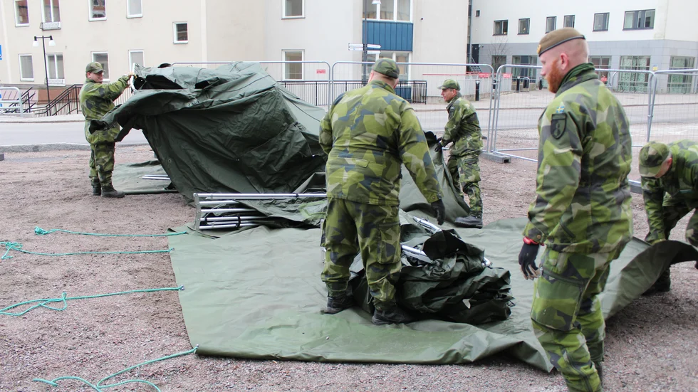 Hemvärnets mannar sätter upp tält utanför US gamla akutintag för medicinska bedömningar av patienter med luftvägssymptom.